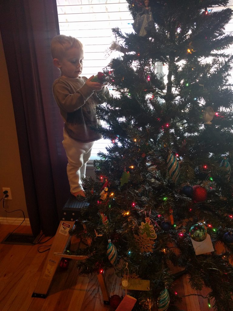 Carter decorating the tree--still in 2/3 of his Olaf costume from the morning before.