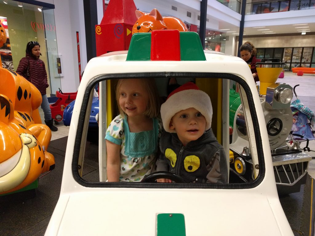 Cuties playing in the car rides at the mall. We don't ever actually put any money in, but they still like sitting in them and pretending to drive to Hawaii.